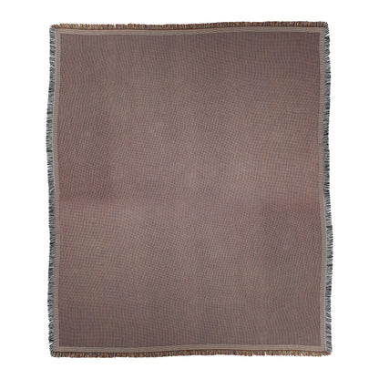 A rectangular woven blanket in a muted mauve-brown hue features a cozy weave, thin light beige-bordered edges, and short, multicolored fringe on all sides. The background is plain white.