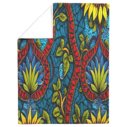 A cozy blanket with a vibrant, bold pattern featuring large yellow, green, and red stylized flowers, leafy vines, and twisting red stems on a rich blue background with cracked texture. This African-inspired fleece blanket has a plain white underside.