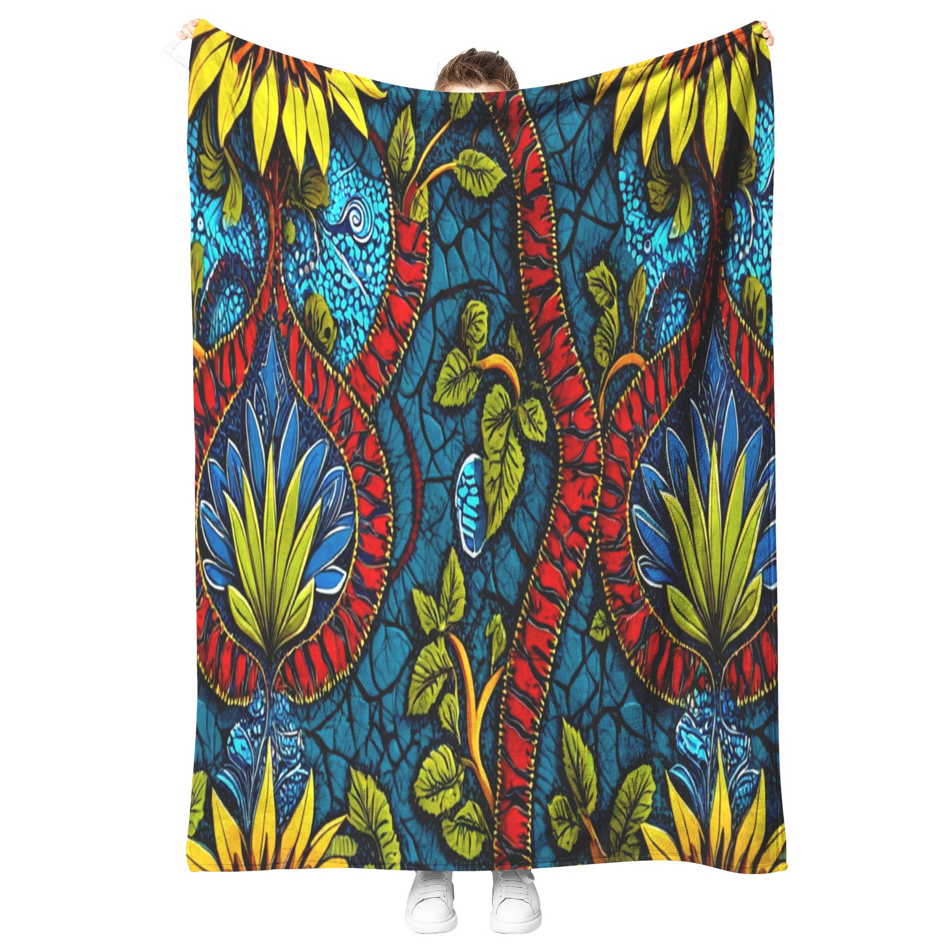 A person stands holding up a vibrant, patterned fabric reminiscent of African-inspired fleece blankets. The fabric features bold, symmetrical designs in yellow, red, blue, and green against a cracked blue backdrop. Only the shoes and part of their head are visible.