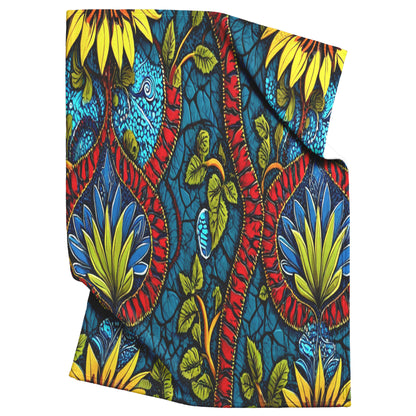 A brightly colored African wax print fabric featuring large yellow sunflowers, blue and green leaves, and bold red vines inspires these African-inspired fleece blankets—cozy sherpa fleece with vibrant, overlapping floral designs and black accents.